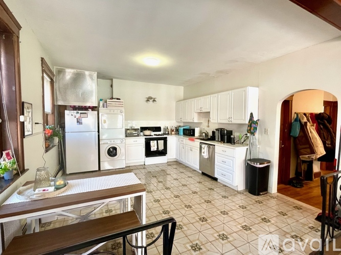 A kitchen with white cabinets and a tiled floor.