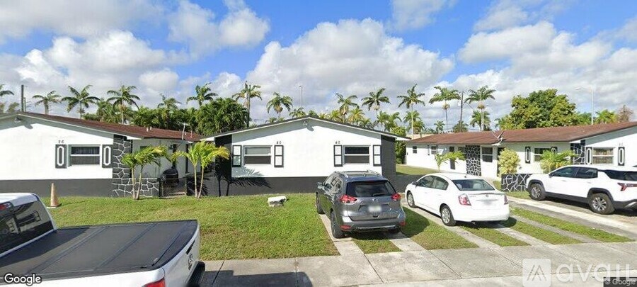 A row of houses with cars parked in front.