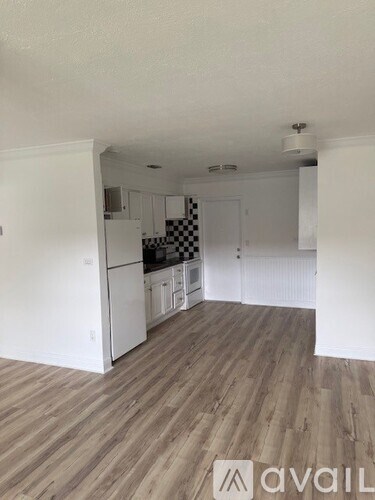 A kitchen with white cabinets and a checkered floor.
