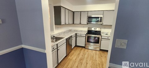 A kitchen with blue walls and wooden floors.