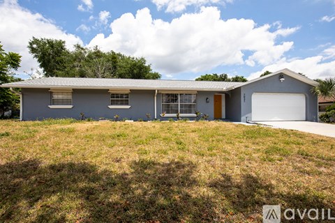 A house with a grey roof and a white garage door is for sale.