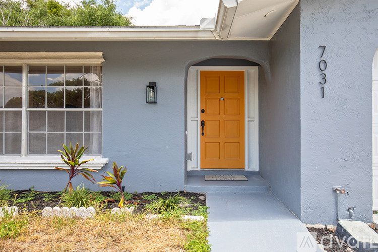 A house with a yellow door and a window with a white frame.