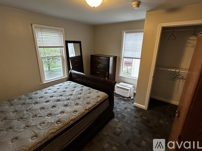 A bedroom with a bed, dresser, and mirror.