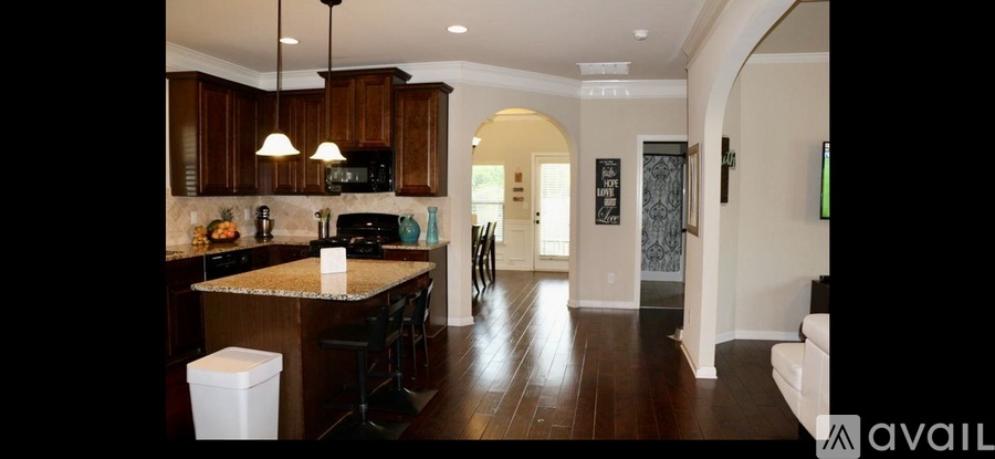 A kitchen with dark wood cabinets and a granite countertop.