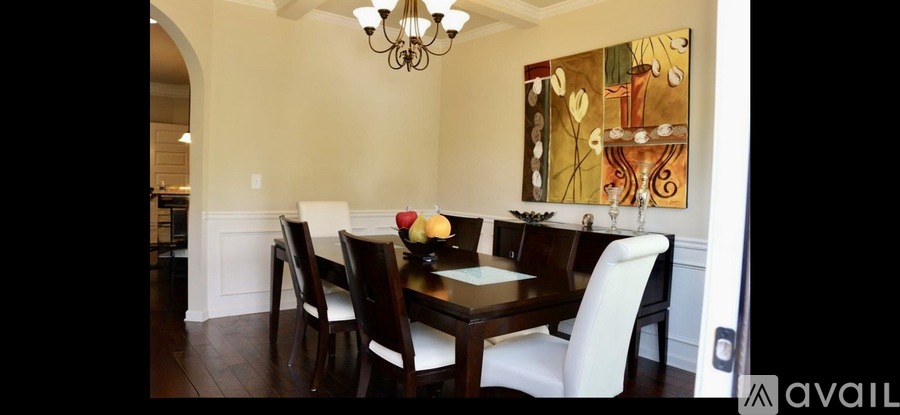 A dining room with a wooden table and chairs.