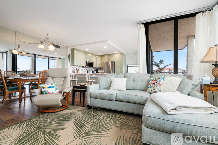 A living room with a grey couch and a wooden floor.