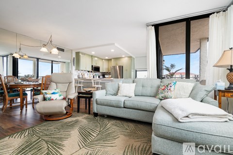 A living room with a grey couch and a wooden floor.