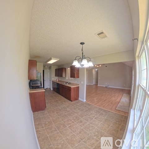 A kitchen with wooden cabinets and a tiled floor.