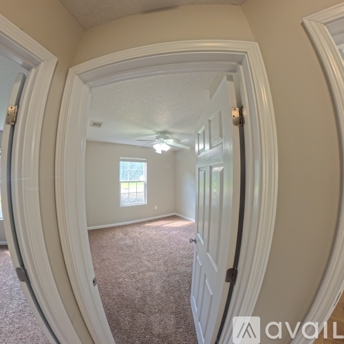 A hallway with a carpeted floor and white walls.