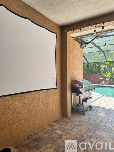 A whiteboard is on the wall in a room with a grill and pool in the background.