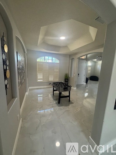 A spacious living room with a dining area and a kitchen in the background.