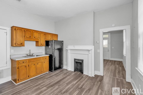 A kitchen with wooden cabinets and a refrigerator.