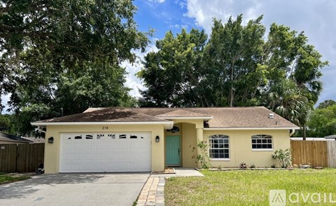 A two-car garage is attached to a house with a yellow and white exterior.