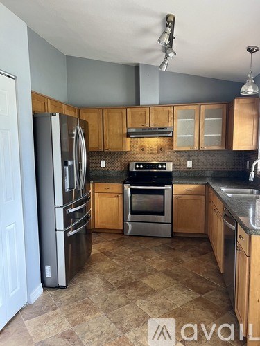 A kitchen with wooden cabinets and a tile floor.