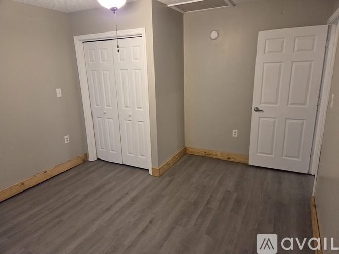 A room with two white doors and a wooden floor.