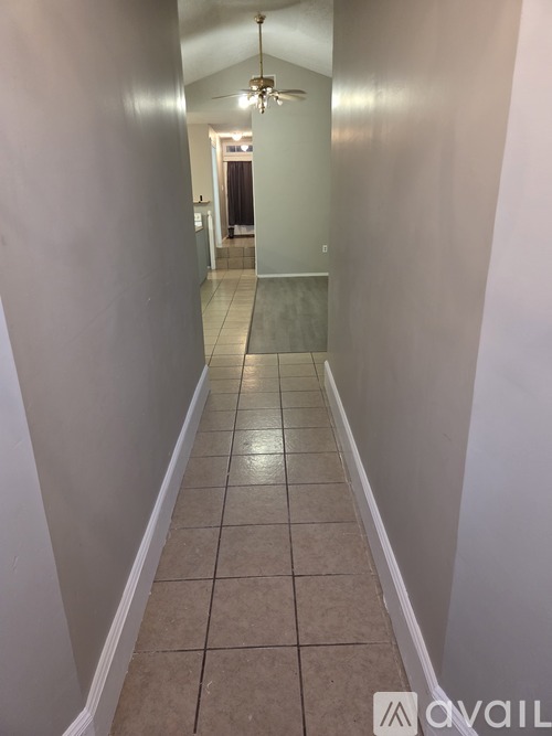 A long hallway with tiled floors and white walls.