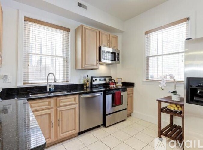 A kitchen with wooden cabinets and black countertops.