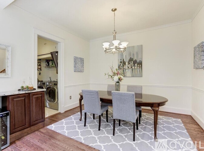 A dining room with a round table and grey chairs.