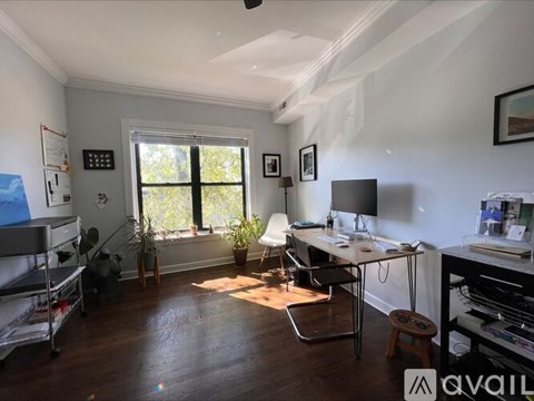 A room with a desk, chair, and a window.