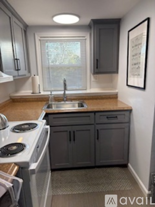 A kitchen with a stove top oven and a sink.