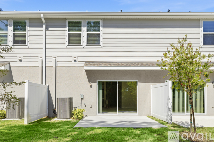 A modern house with a white exterior and a tree in front.