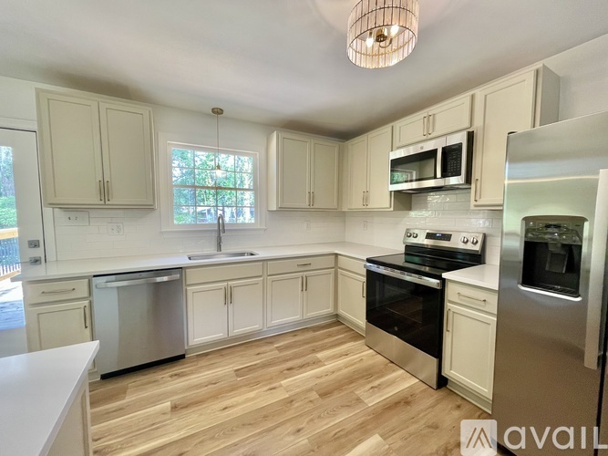 A kitchen with wooden floors and white appliances.
