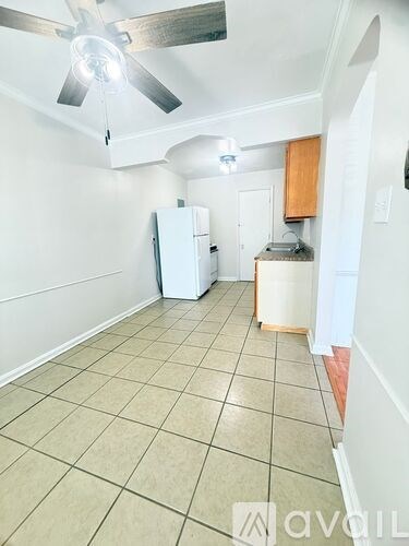A kitchen with a white refrigerator and a ceiling fan.
