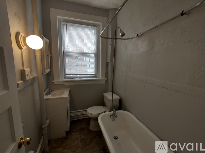 A bathroom with a toilet, sink, and bathtub.