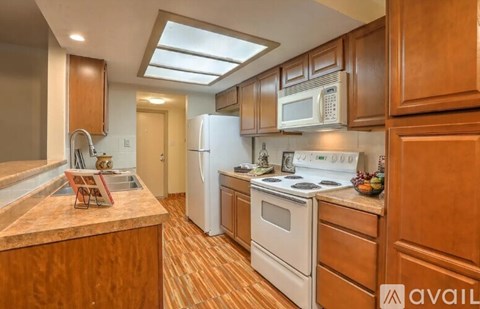 A kitchen with wooden cabinets and a white refrigerator.