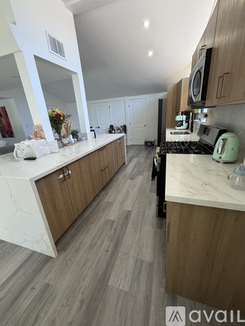 A kitchen with wooden cabinets and a marble countertop.