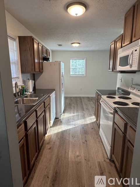 A kitchen with wooden cabinets and a white refrigerator.