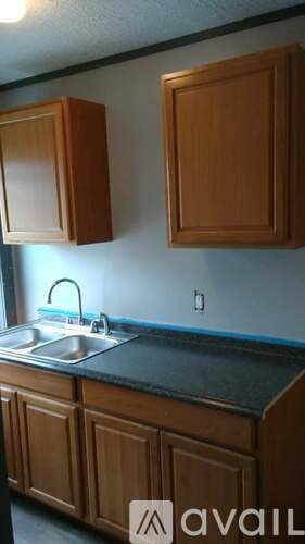 A kitchen with wooden cabinets and a black countertop.