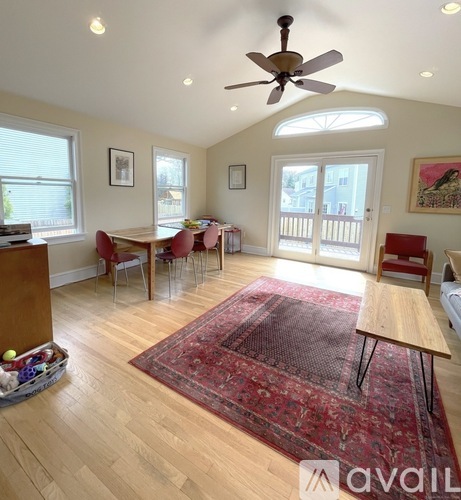 A room with a ceiling fan and a rug on the floor.