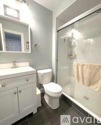 A bathroom with a toilet, sink, and mirror.