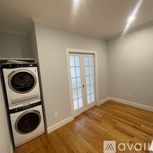 A room with a washer and dryer stacked on top of each other.