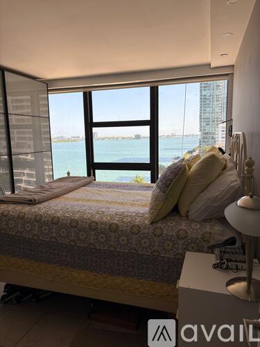 A bedroom with a large bed and a view of the water.