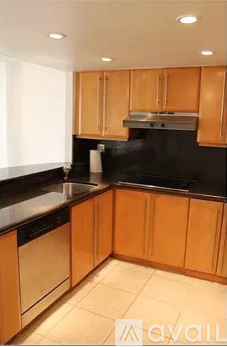 A kitchen with wooden cabinets and black countertops.