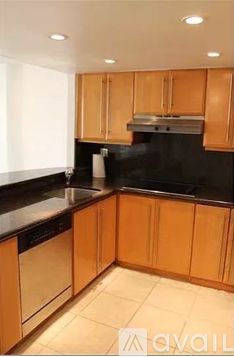 A kitchen with wooden cabinets and black countertops.