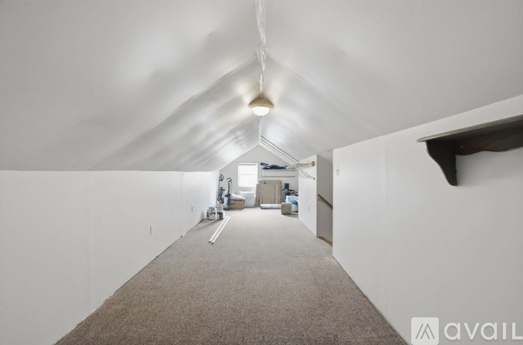 A long, empty hallway with a carpeted floor and white walls.