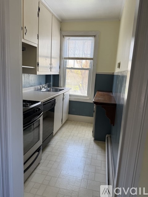 A kitchen with white cabinets and a white stove top oven.