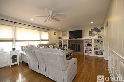A living room with a grey couch and a fireplace.