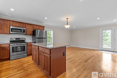 A kitchen with wooden cabinets and a stainless steel refrigerator.