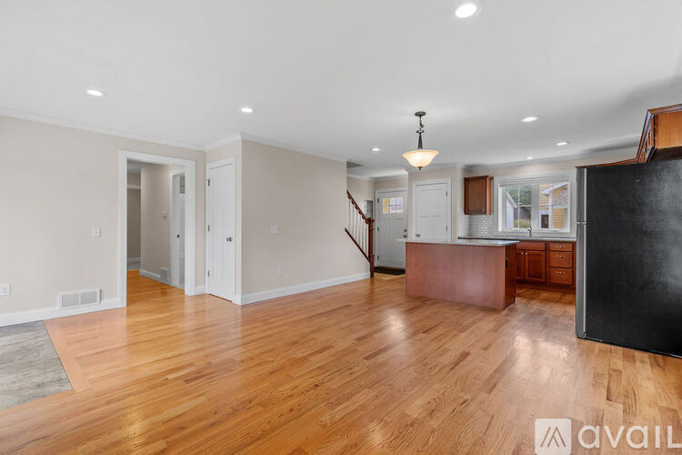 A spacious living room with hardwood floors and a central island.