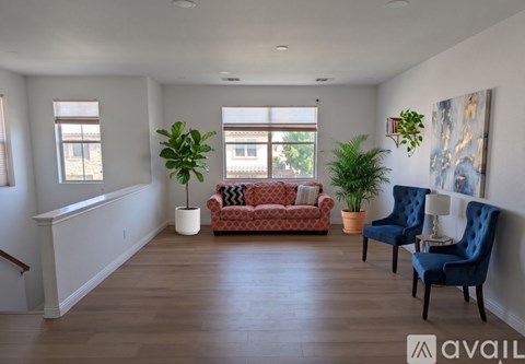 A living room with a red couch and blue chairs.