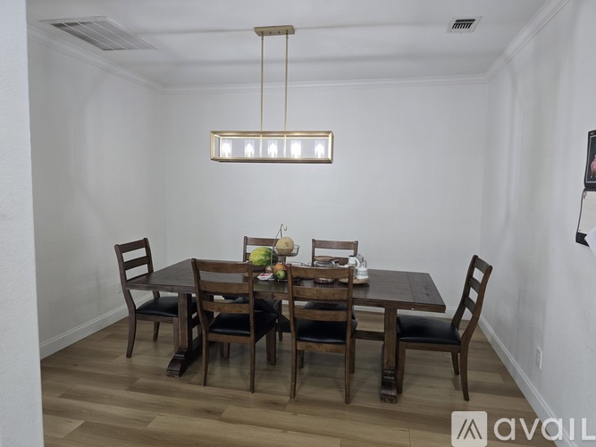 A dining room with a table set for six.