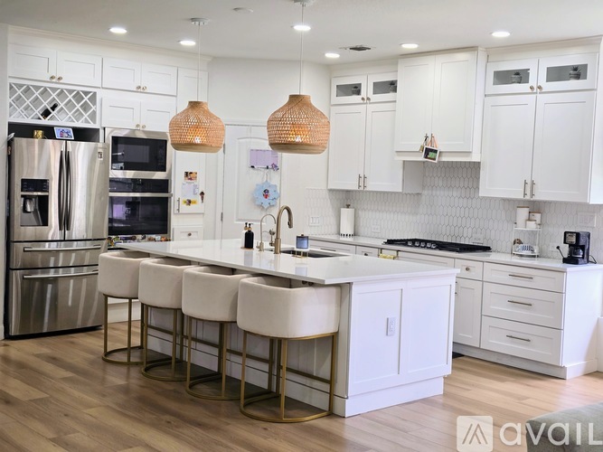 A kitchen with white cabinets and a marble countertop.
