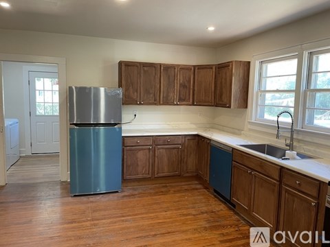 A kitchen with wooden cabinets and a blue fridge.