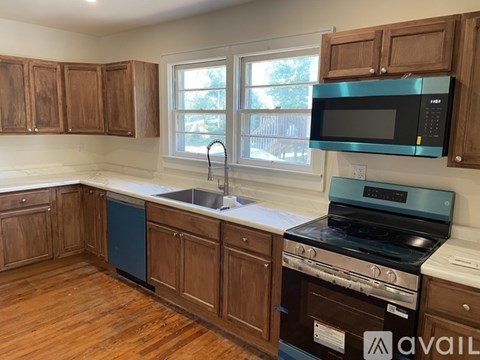 A kitchen with wooden cabinets and a black stove top oven.