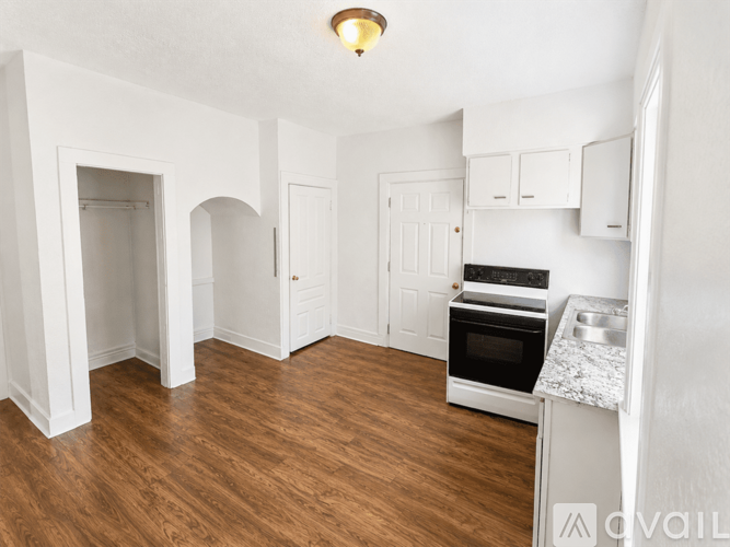 A kitchen with a wooden floor and white walls.