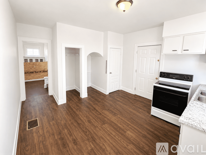 A kitchen area with a sink, oven, and cabinets.